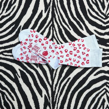 Charger l'image dans la galerie, Atelier Grenade chaussettes léopard rouges en bambou ultra-doux sur fond zébré noir et blanc.